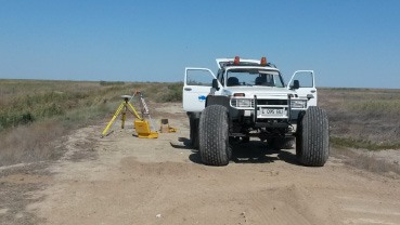 Survey vehicle parked beside roadside equipment